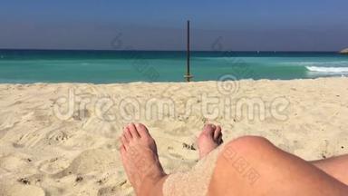 沙滩上的沙滩上的雄脚，背景海水，蓝色海水